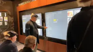 older man using flag list to find battles flag fought in on 98in planar touch screen